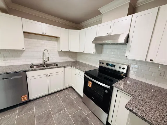a kitchen with a sink stove top oven and cabinets