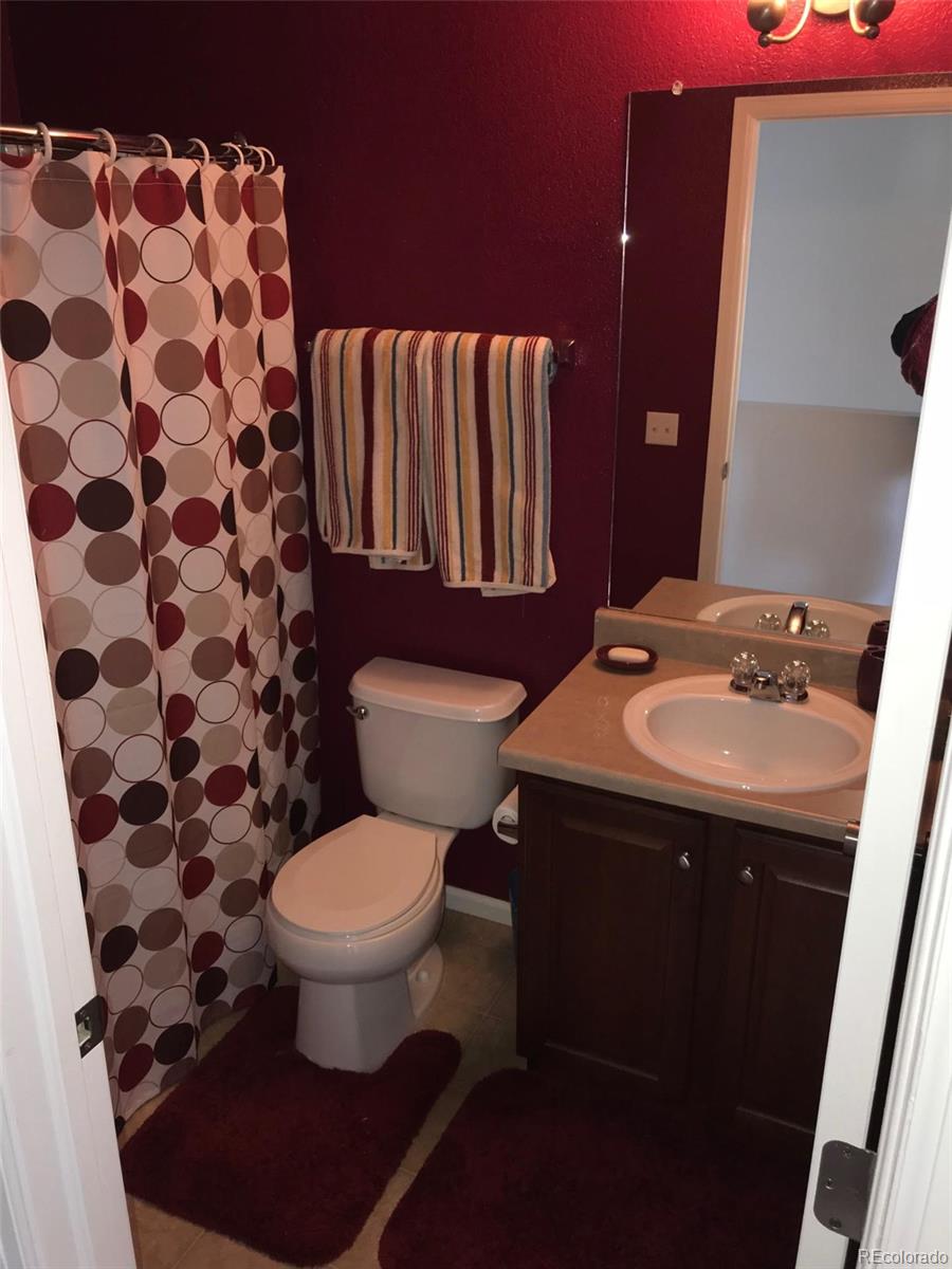 5556 Flanders Way Denver, CO 80249 - Photo 15 of 23 a bathroom with a sink toilet and shower