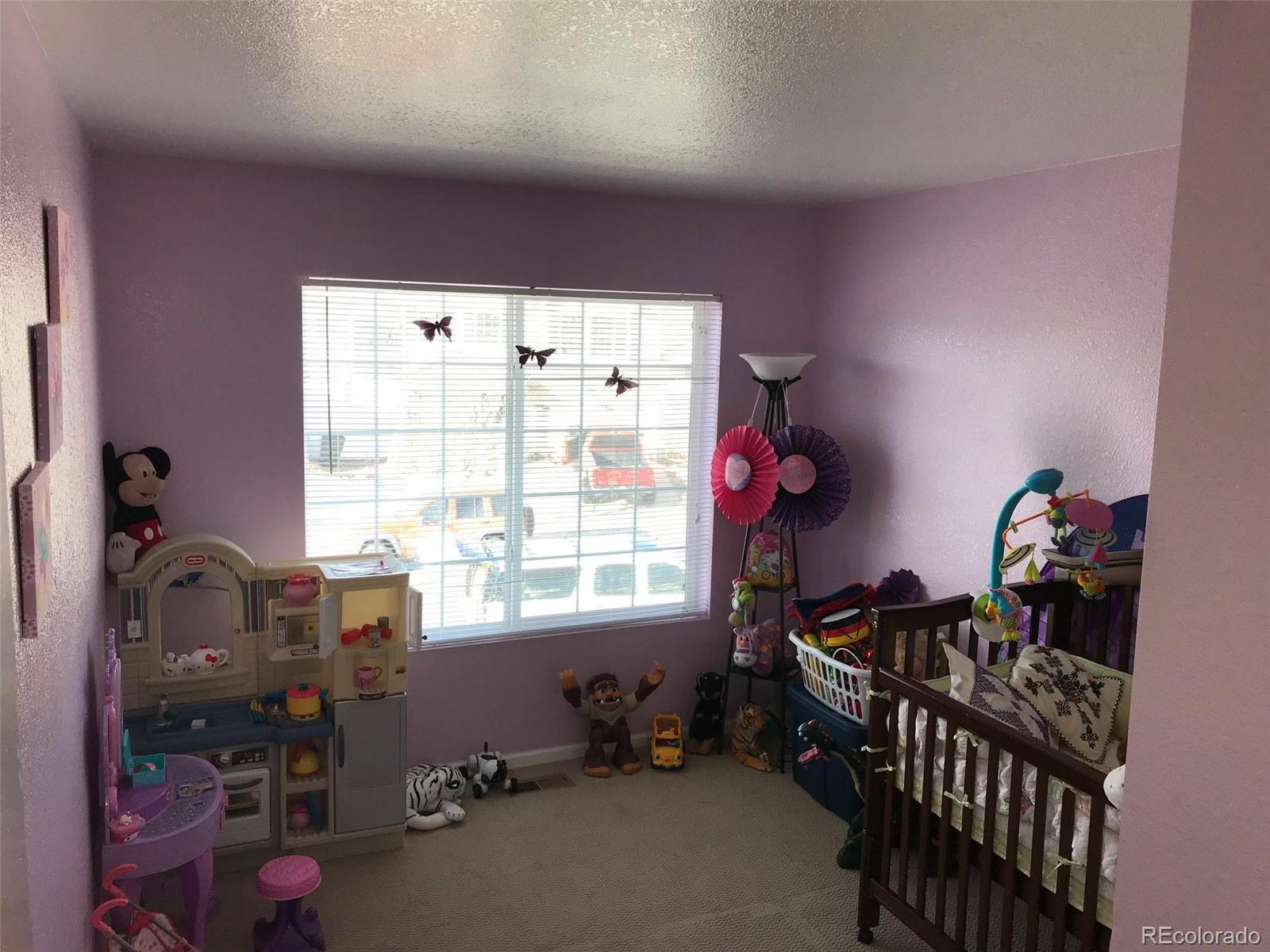 5556 Flanders Way Denver, CO 80249 - Photo 17 of 23 a bedroom with furniture and a window