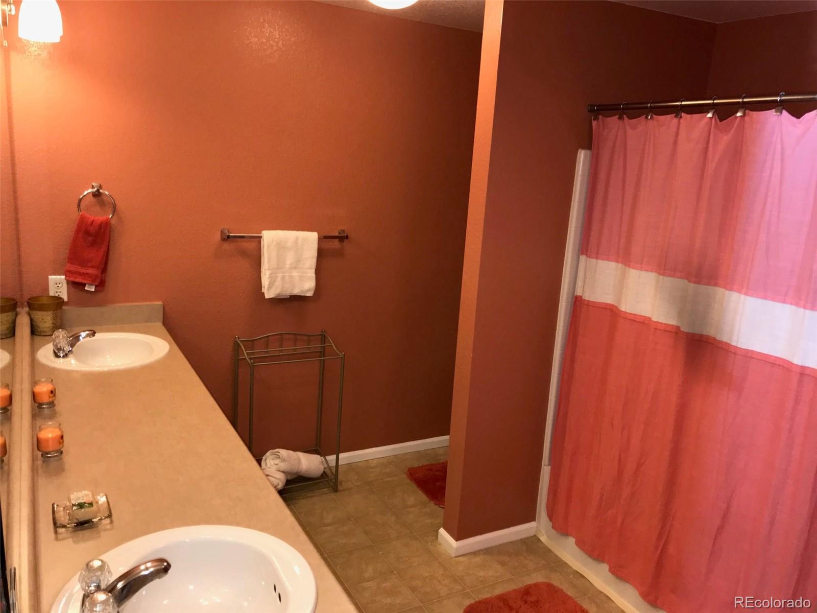 5556 Flanders Way Denver, CO 80249 - Photo 20 of 23 a bathroom with a sink and mirror