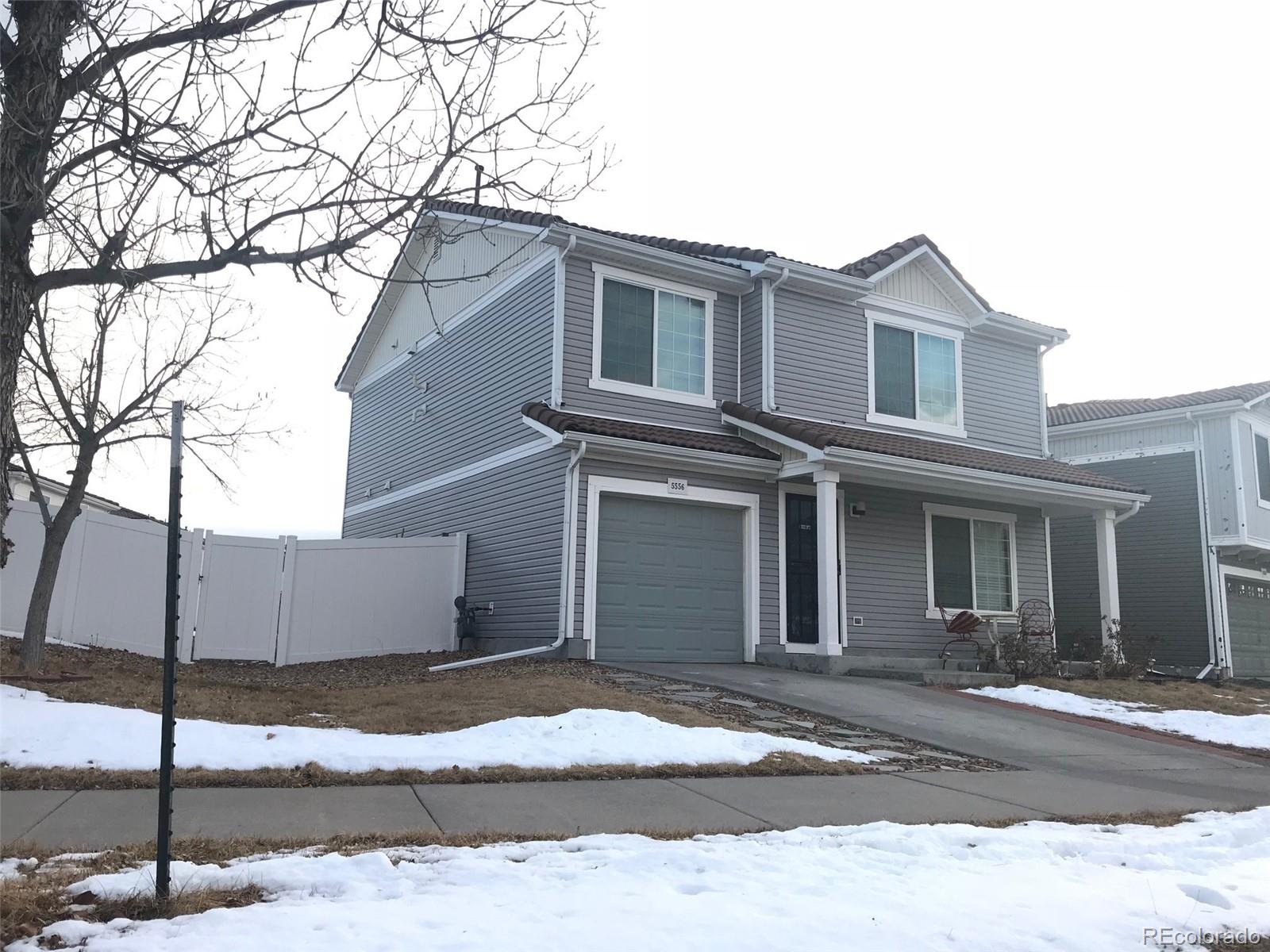 5556 Flanders Way Denver, CO 80249 - Photo 2 of 23 a house that has a tree in front of it
