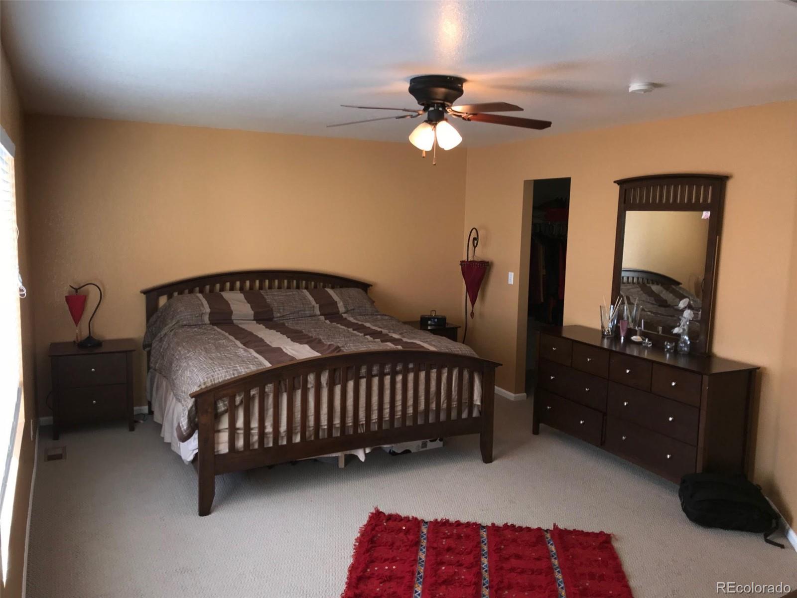 5556 Flanders Way Denver, CO 80249 - Photo 21 of 23 a bedroom with a bed and a dresser