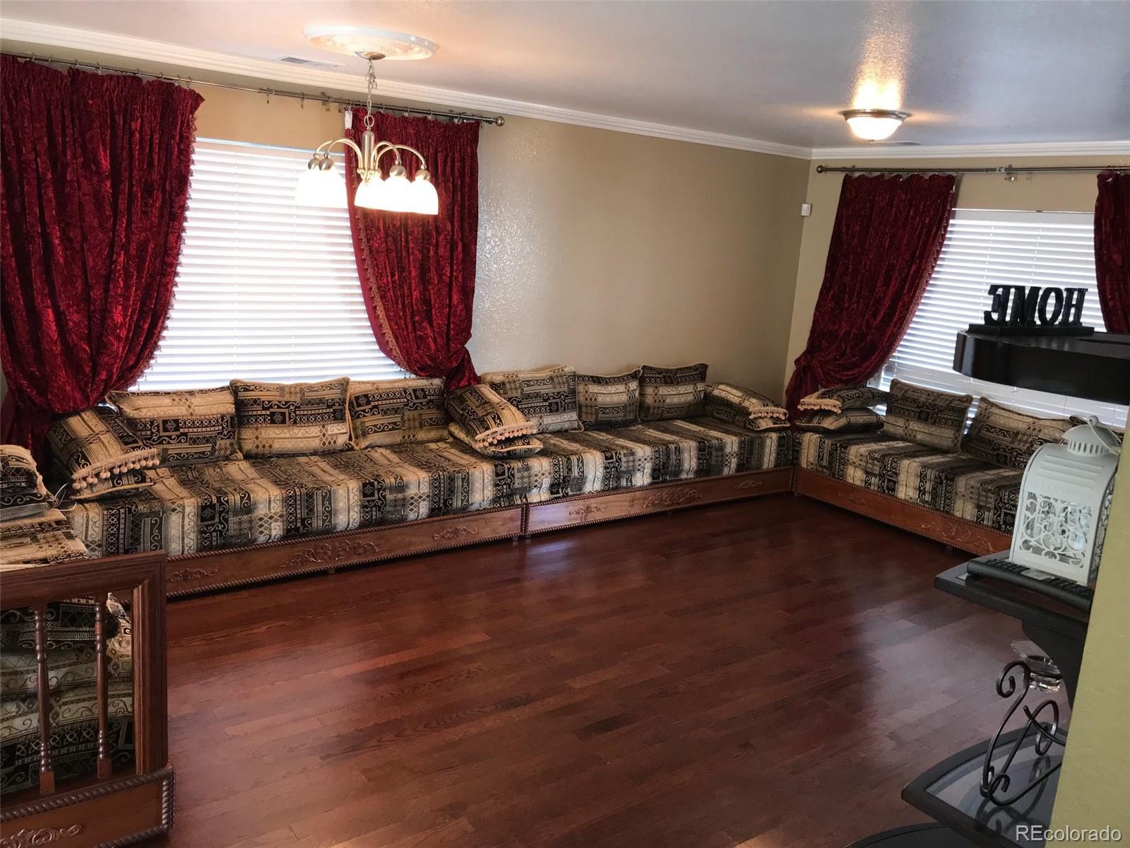 5556 Flanders Way Denver, CO 80249 - Photo 3 of 23 a very nice looking room with wooden floor and furniture