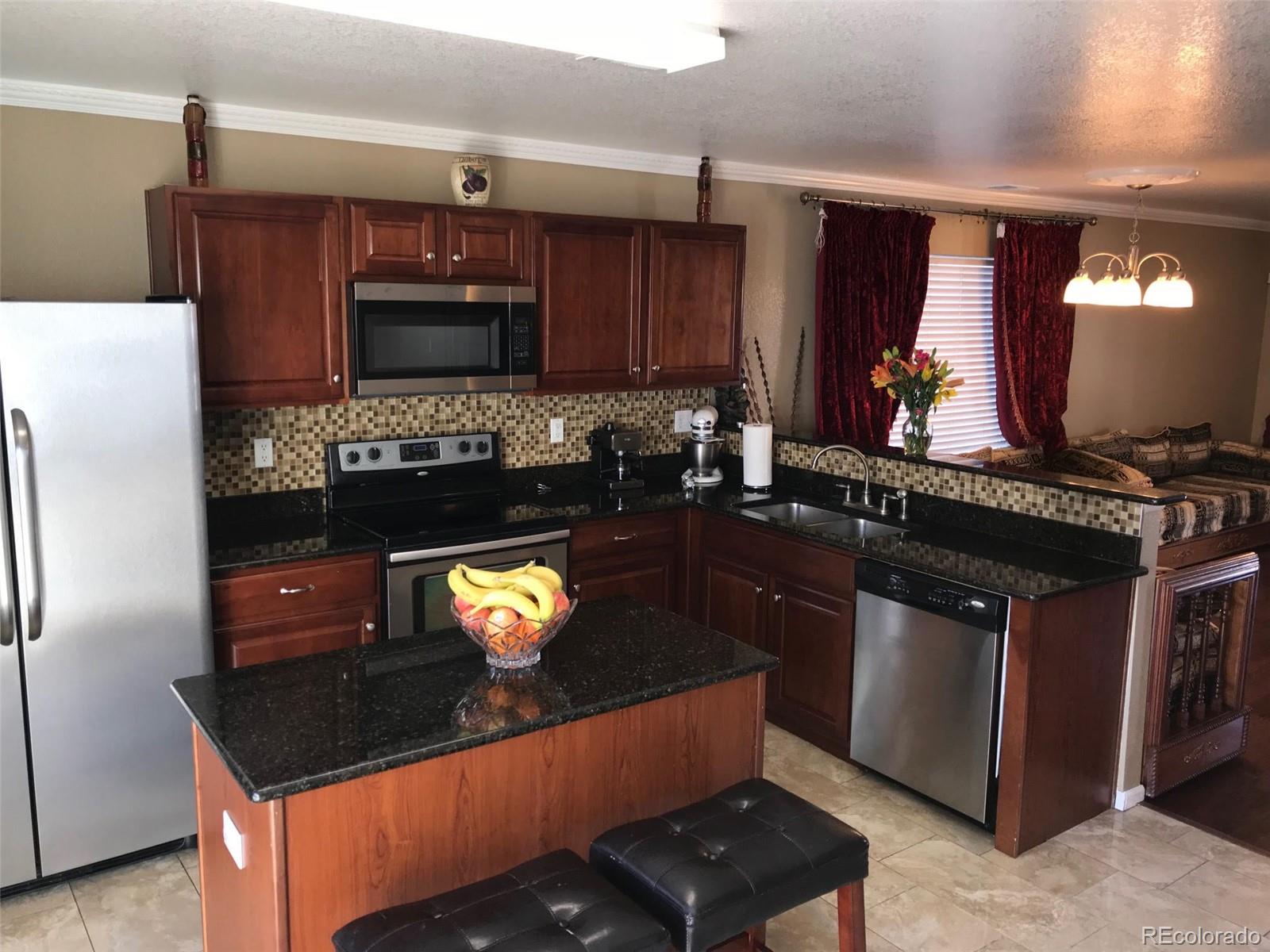 5556 Flanders Way Denver, CO 80249 - Photo 7 of 23 a kitchen with a stove and a refrigerator