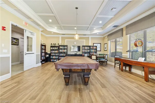 a dining hall with stainless steel appliances granite countertop a stove a sink a dining table and chairs with wooden floor