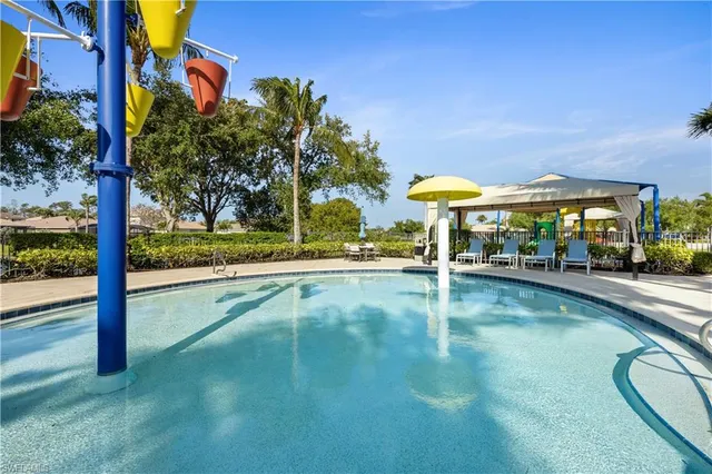 a view of swimming pool with a table and chairs under an umbrella