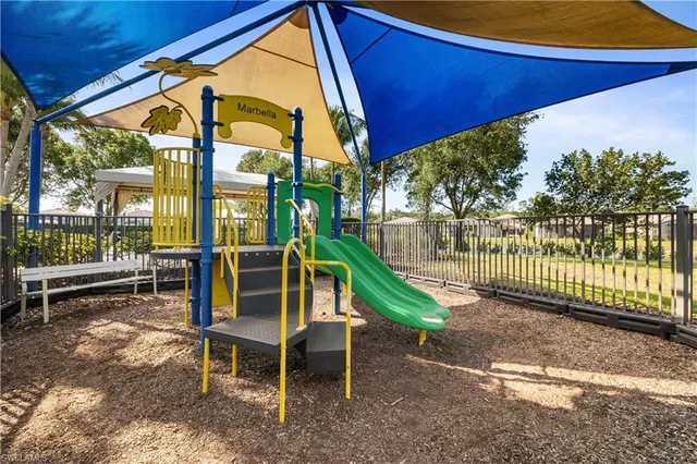 a view of a chair and tables in the back yard of the house