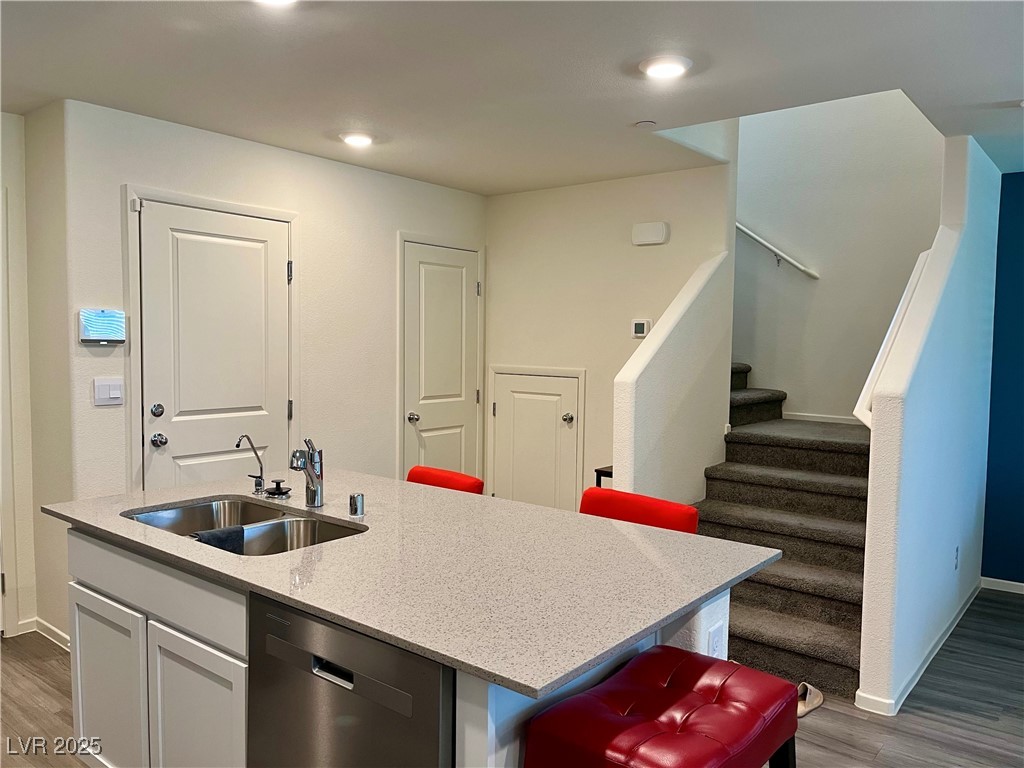 4862 Orchid Rdg Avenue Las Vegas, NV 89141 - Photo 15 of 48 Kitchen w/island w/breakfast bar, quartz countertops, white shaker cabinets, stainless steel Whirlpool appliances including refrigerator, microwave, dishwasher, stove, reverse osmosis, recessed lights, luxury vinyl plank floors & pantry.