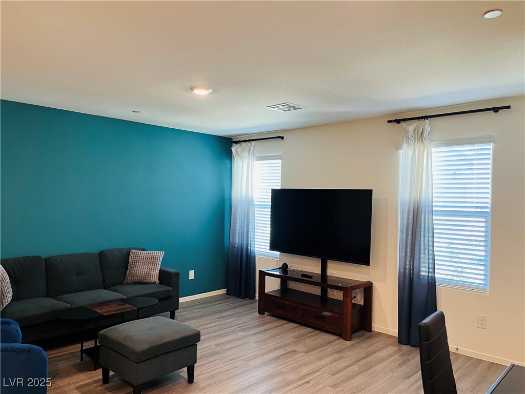 4862 Orchid Rdg Avenue Las Vegas, NV 89141 - Photo 6 of 48 Living room with luxury vinyl plank floors, ceiling light, blinds & curtains.