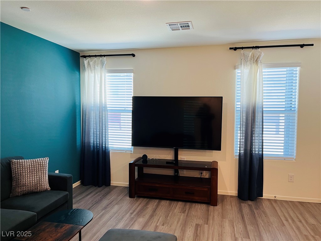 4862 Orchid Rdg Avenue Las Vegas, NV 89141 - Photo 7 of 48 Living room with luxury vinyl plank floors, ceiling light, blinds & curtains.