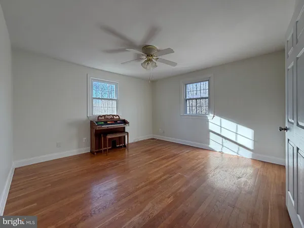 a living room with hard wood floors and a ceiling fan