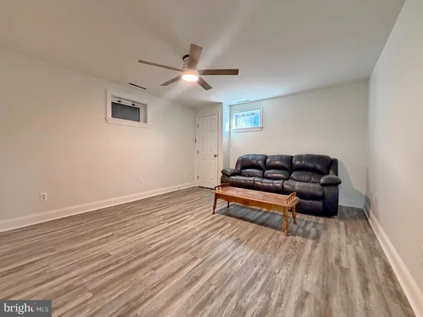 a view of a room with wooden floor and ceiling fan