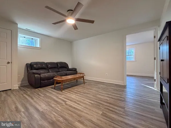a living room with furniture and a ceiling fan