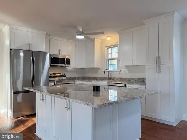 a kitchen with stainless steel appliances granite countertop a refrigerator sink and stove