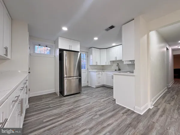 a kitchen with a refrigerator a sink and cabinets
