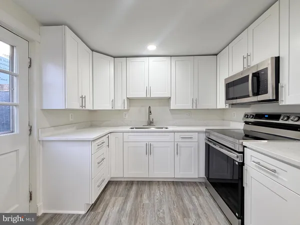 a kitchen with stainless steel appliances granite countertop a stove and white cabinets