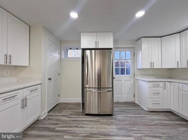 a kitchen with wooden floors and stainless steel appliances
