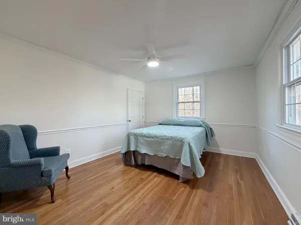 a bedroom with a bed wooden floor and window