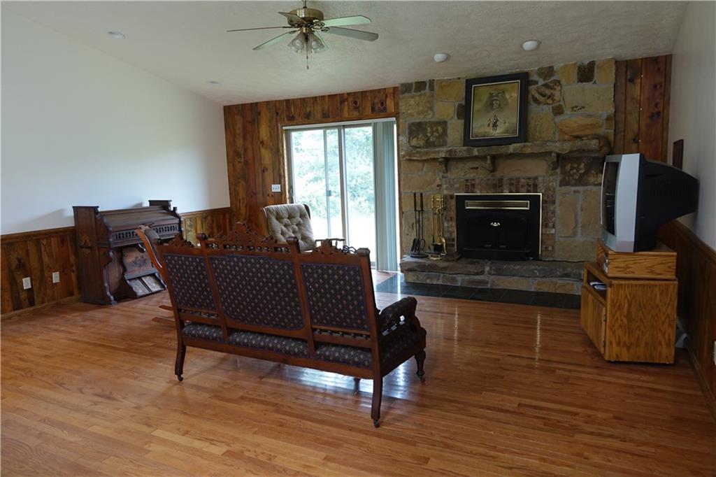 917 New Castle Road Butler, PA 16001 - Photo 3 of 25 Living room with hardwood flooring, stone fireplace, and sliding glass door