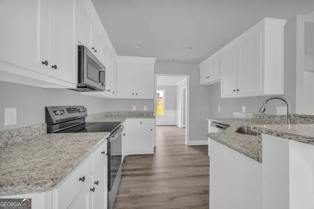 a view of an empty room with wooden floor fireplace and a window