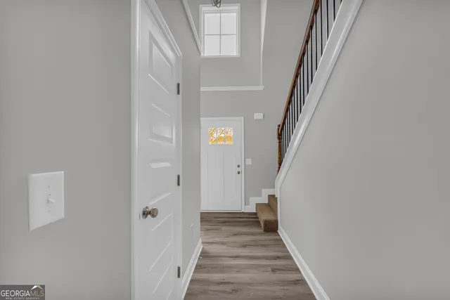 a view of a hallway with wooden floor and entryway