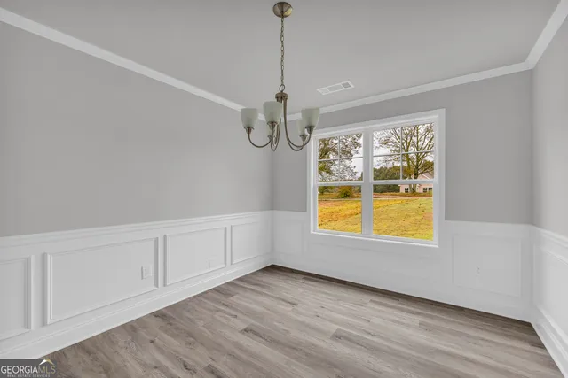 an empty room with a window and wooden floor