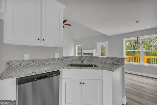 a kitchen with granite countertop white cabinets and a sink