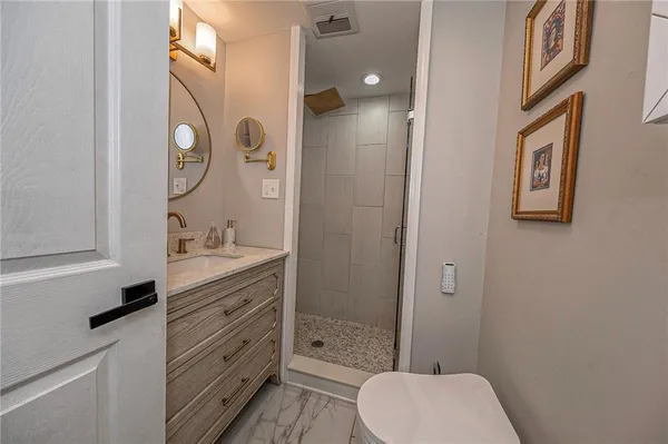 a bathroom with a granite countertop toilet a sink and a mirror