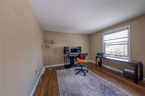 a view of a workspace with furniture and a window