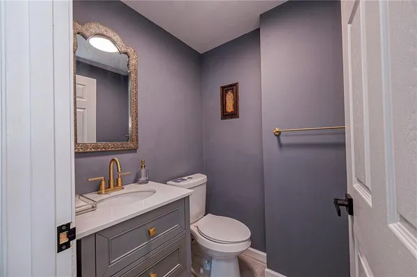a bathroom with a granite countertop toilet sink and mirror