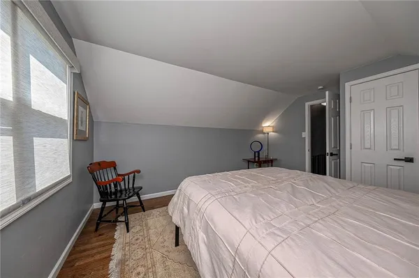 a bedroom with a bed chair and window