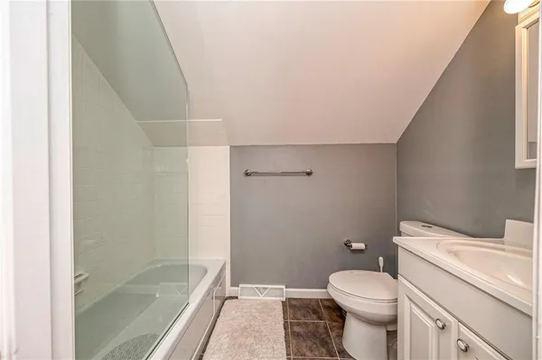 a bathroom with a granite countertop toilet and a shower