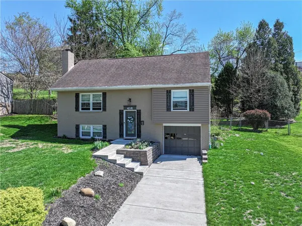 a front view of a house with a garden and plants