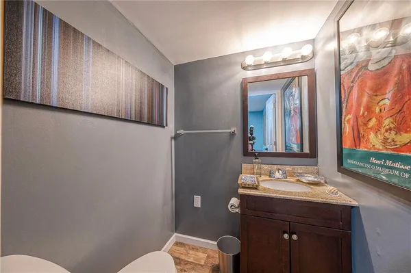 a bathroom with a sink a toilet a mirror and shower curtain