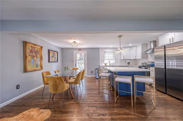 a dining room with furniture a rug and kitchen view