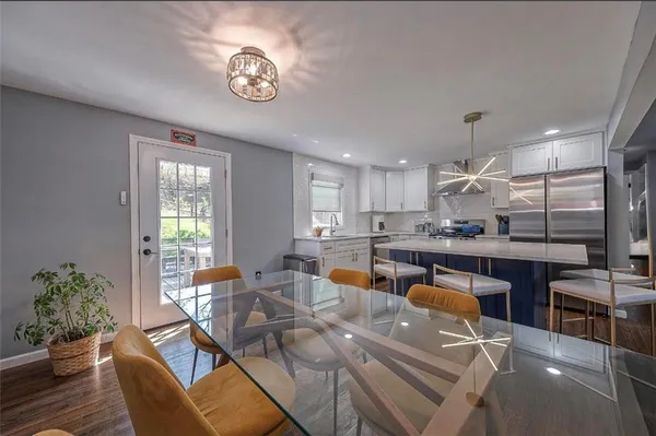 a living room with furniture kitchen view and a large window