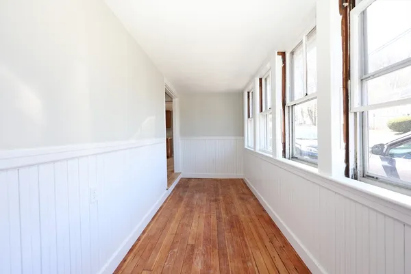 a view of a hallway with wooden floor and staircase