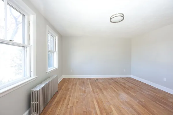 a view of a room with wooden floor and windows