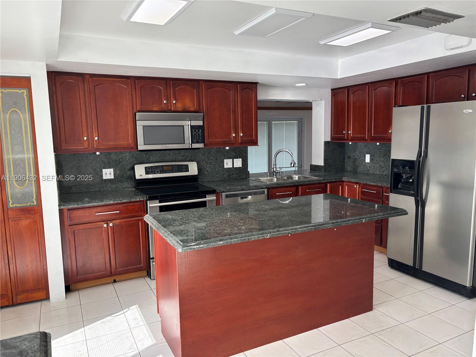 4314 Southwest 148th Court Miami, FL 33185 - Photo 13 of 32 a kitchen with stainless steel appliances granite countertop a stove a sink dishwasher a refrigerator and a microwave oven