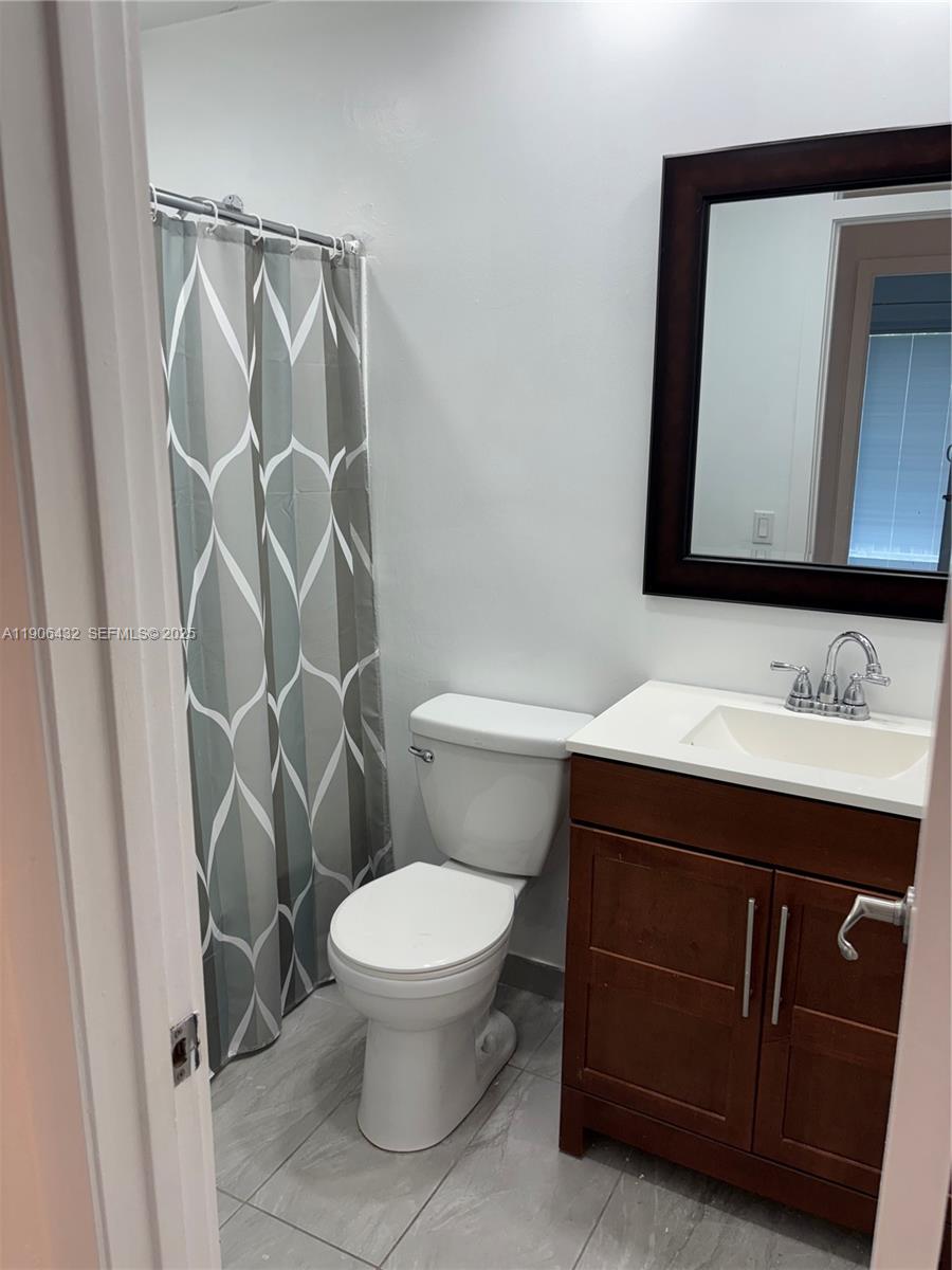 4314 Southwest 148th Court Miami, FL 33185 - Photo 19 of 32 a bathroom with a toilet sink and mirror