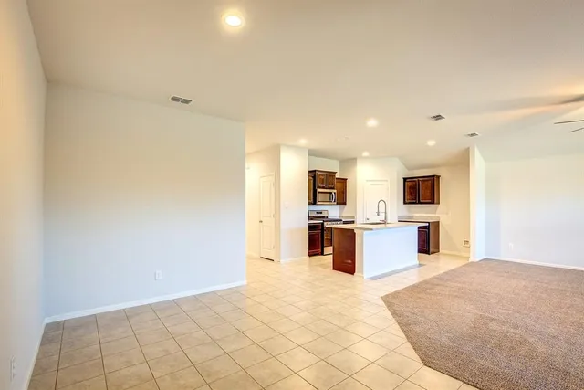 a view of kitchen with kitchen island microwave and cabinets