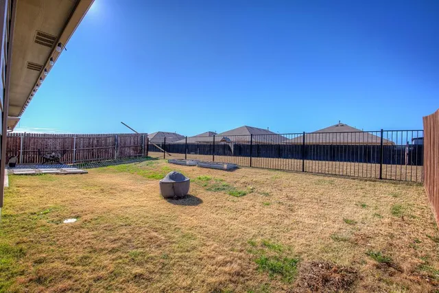a view of a backyard with a floor to ceiling window and wooden fence