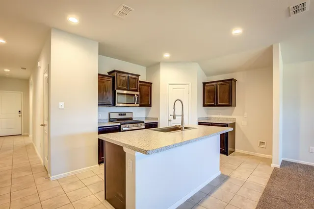 a kitchen with a sink a stove top oven and refrigerator