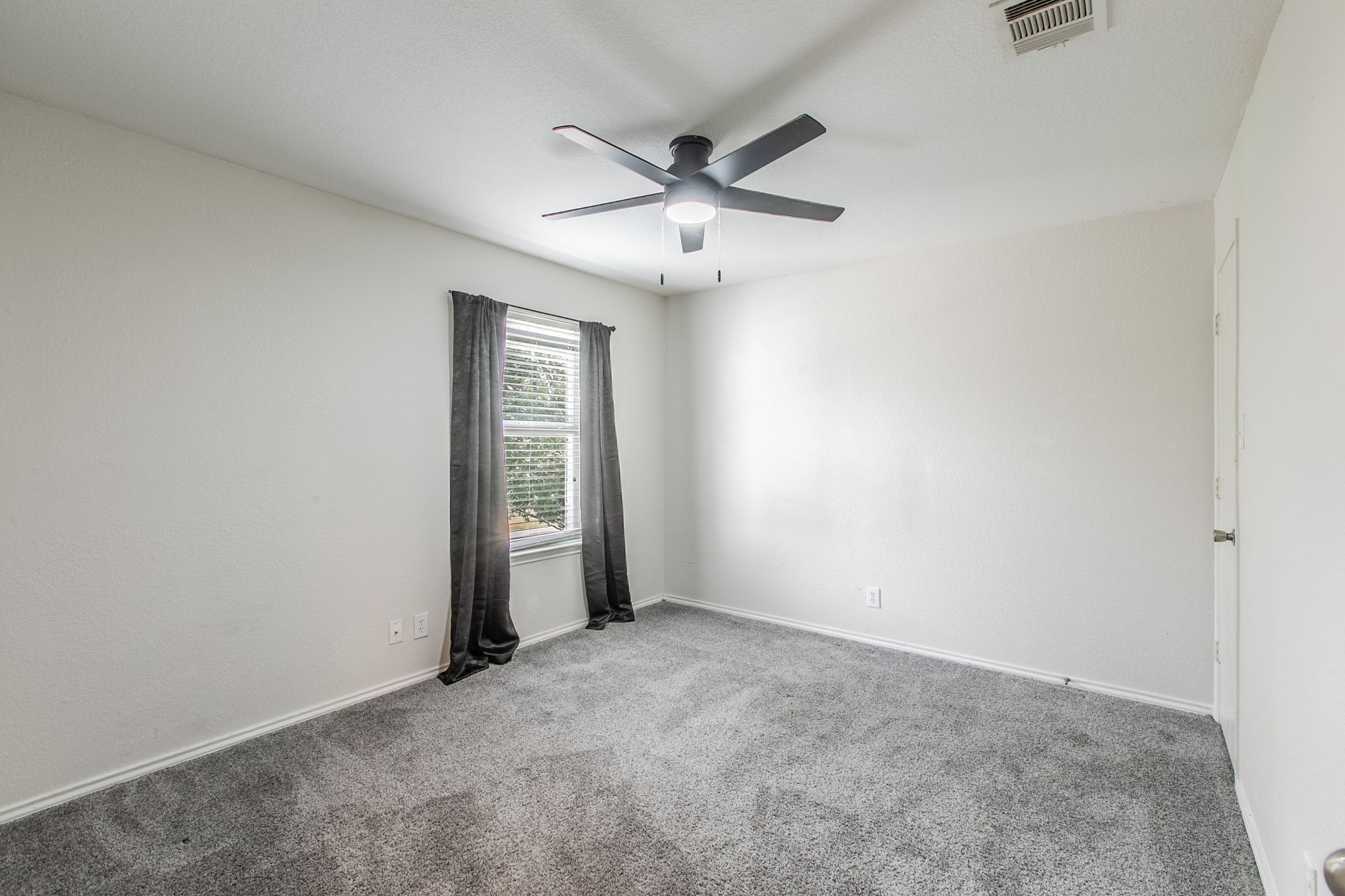 157 Lex Word Kyle, TX 78640 - Photo 22 of 34 A window bathes the carpeted room with natural light.