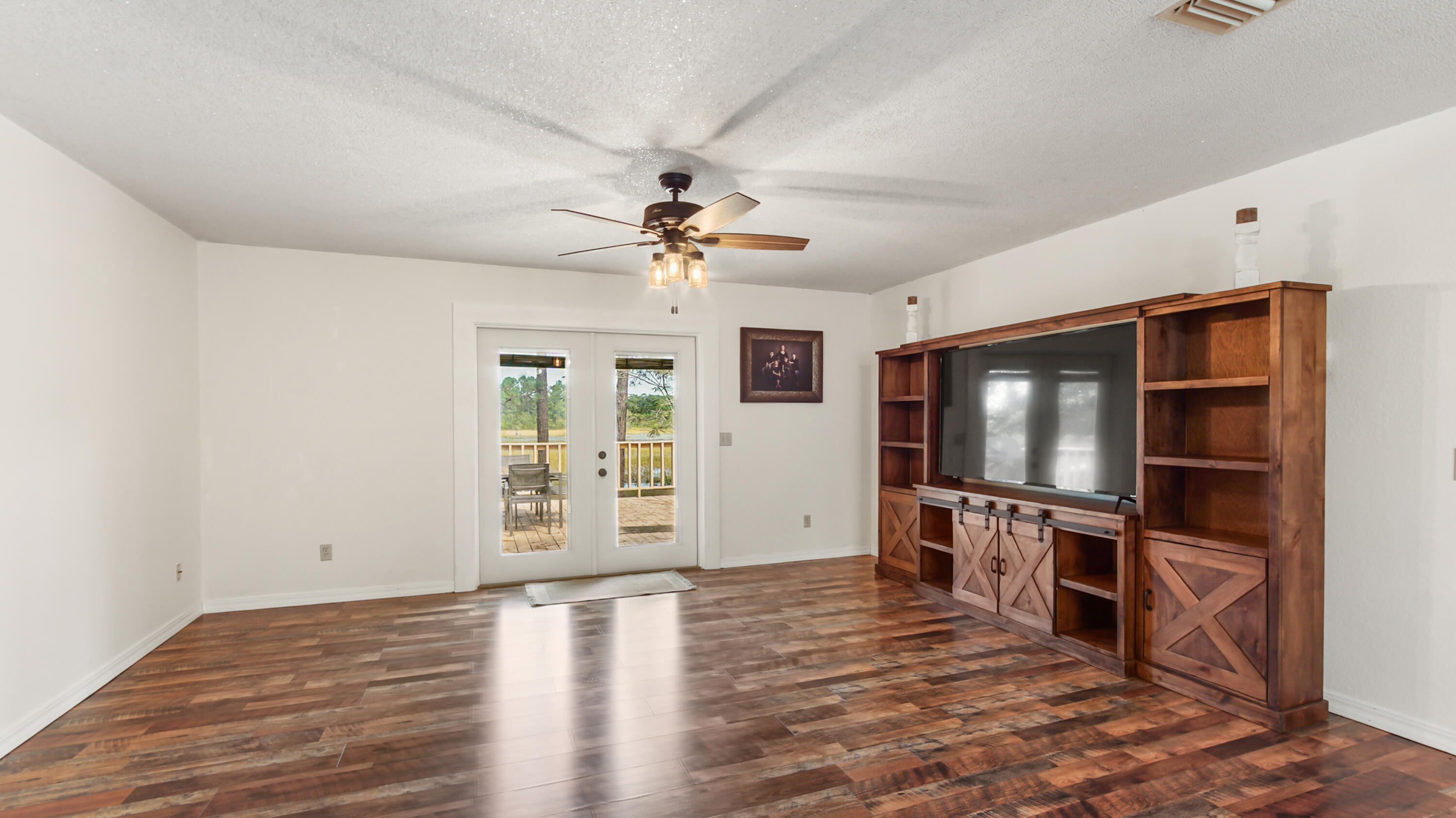 35 Marion Drive DeFuniak Springs, FL 32433 - Photo 6 of 38 a view of a livingroom with wooden floor a ceiling fan and a kitchen space