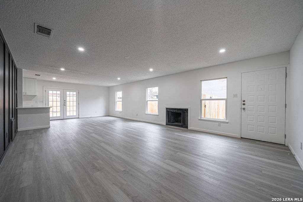 9131 Valley Ridge San Antonio, TX 78250 - Photo 2 of 12 an empty room with wooden floor and windows