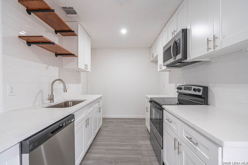 9131 Valley Ridge San Antonio, TX 78250 - Photo 4 of 12 a kitchen with stainless steel appliances granite countertop a sink and a stove top oven