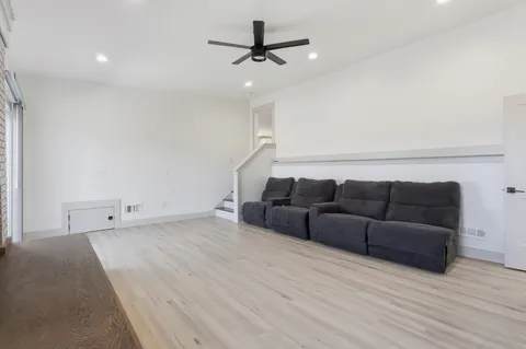 a living room with furniture and a ceiling fan
