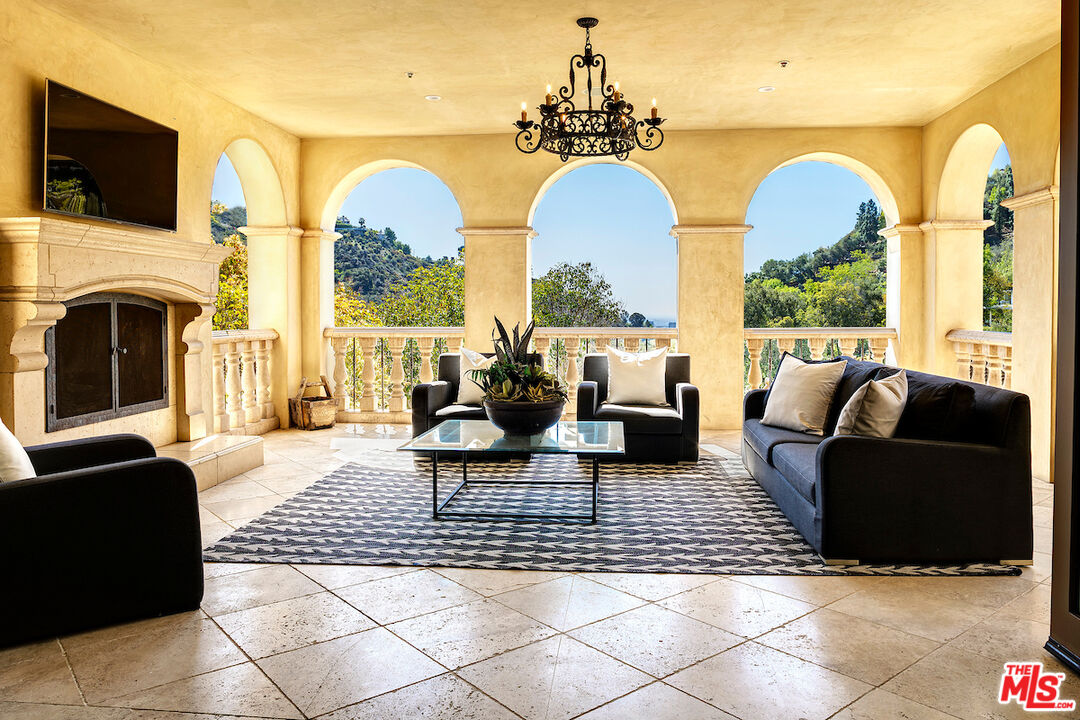 11025 Anzio Road Los Angeles, CA 90077 - Photo 13 of 34 a living room with fireplace furniture and a large window