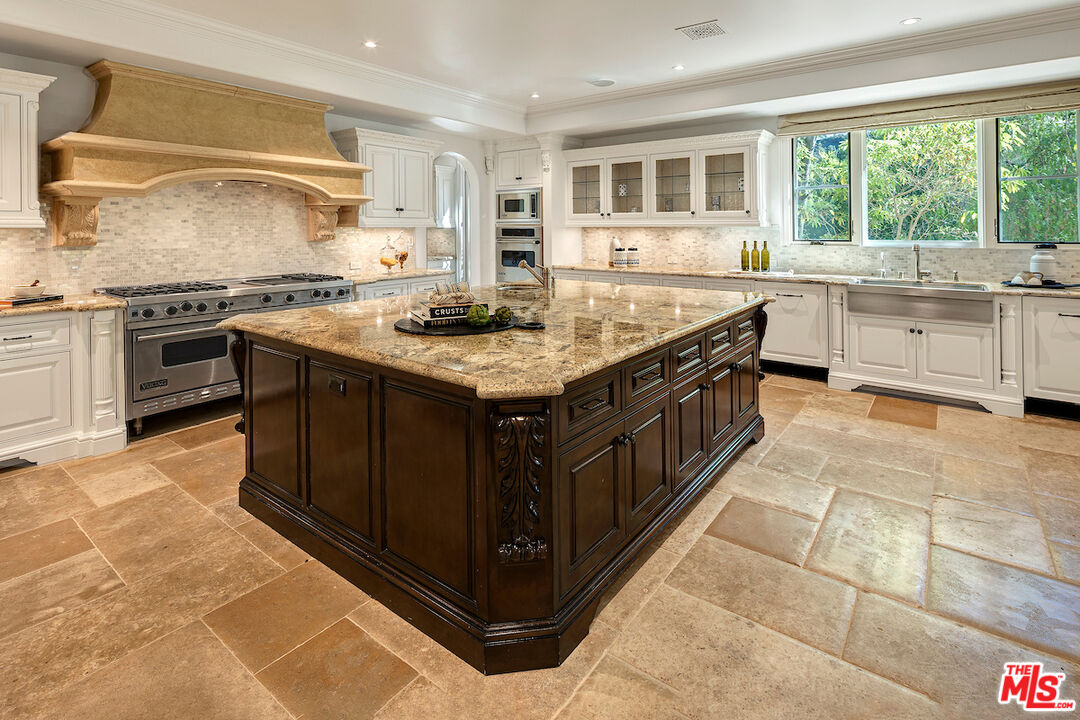 11025 Anzio Road Los Angeles, CA 90077 - Photo 15 of 34 a kitchen with a stove sink and cabinets